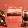 Lamora The Baristro Chiang Mai Lica Coffee Estate drip bag with coffee cherries and a steaming cup of pour-over coffee