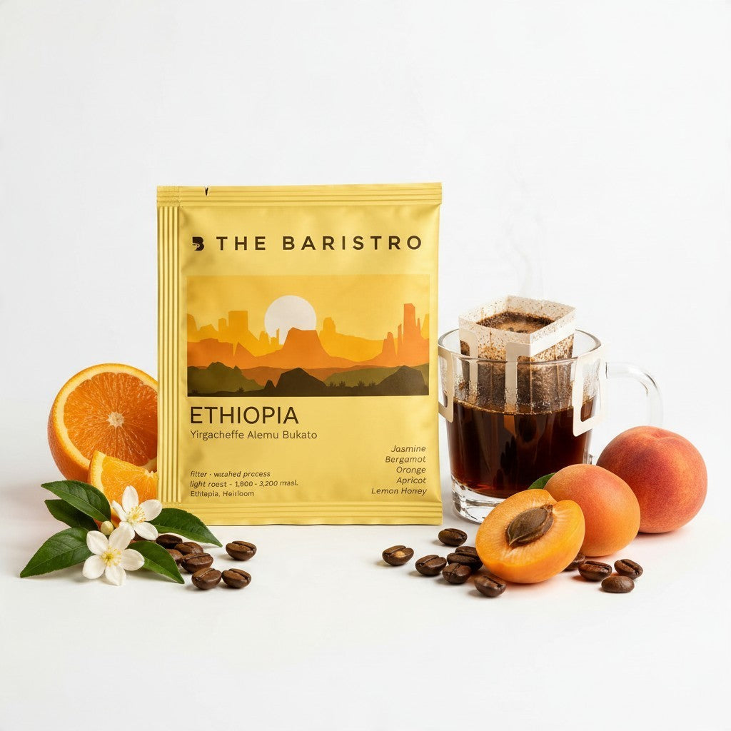 Lamora The Baristro Ethiopia Yirgacheffe drip coffee bag with fresh orange, apricot, and coffee beans on white surface